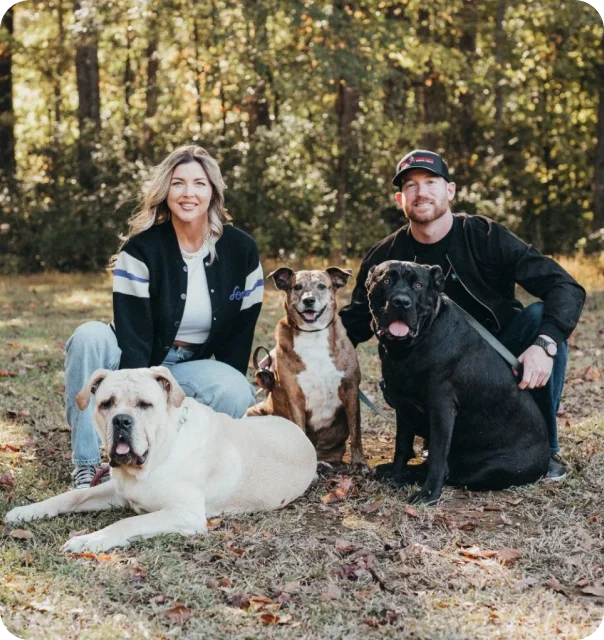 A Couple poses with three dogs